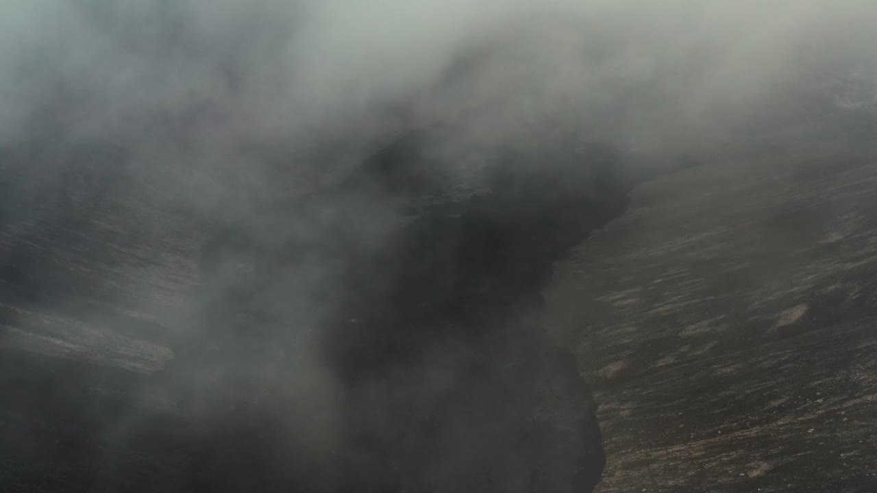 无人机在冰岛雷克雅内半岛fagradalsjall火山喷发形成的熔岩场上空的低空云层中飞行视频下载