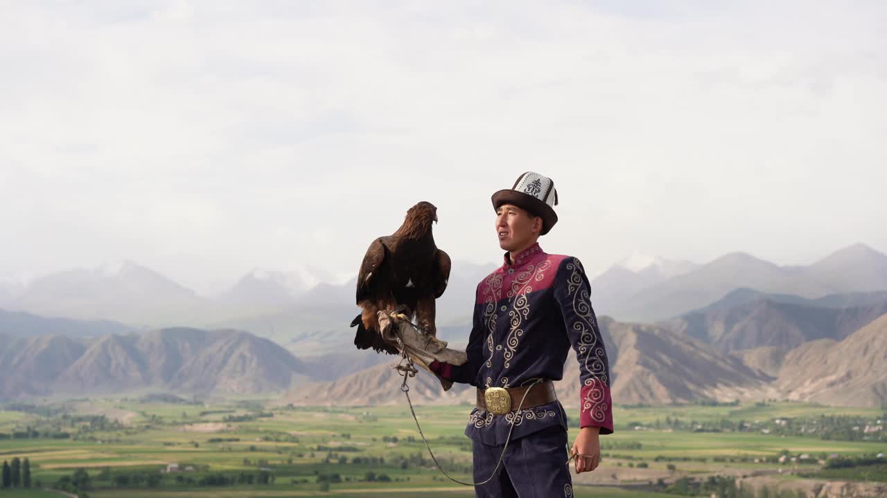 鹰猎人站在吉尔吉斯斯坦山脉的背景视频素材