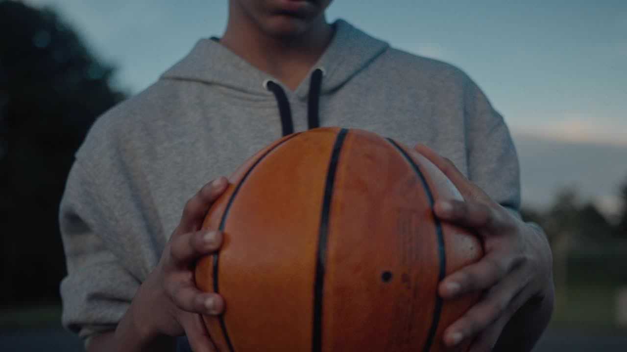 一个年轻的篮球运动员的肖像拿着一个球视频下载