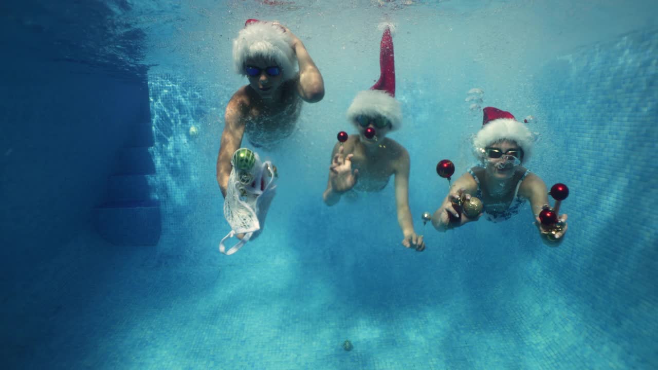 孩子们在夏天圣诞节的游泳池里游泳视频素材