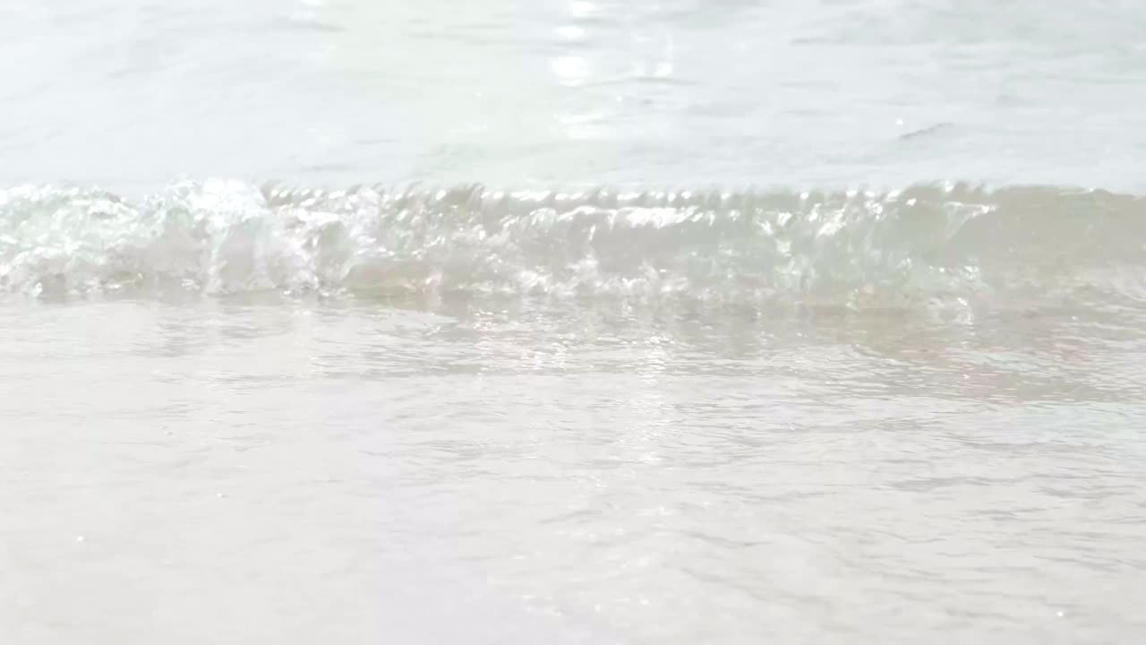 清澈的海浪在沙滩上翻滚。暑假，放松和旅行视频素材