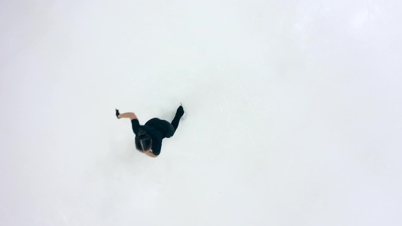 一个女孩在溜冰场上快速旋转的俯视图视频下载