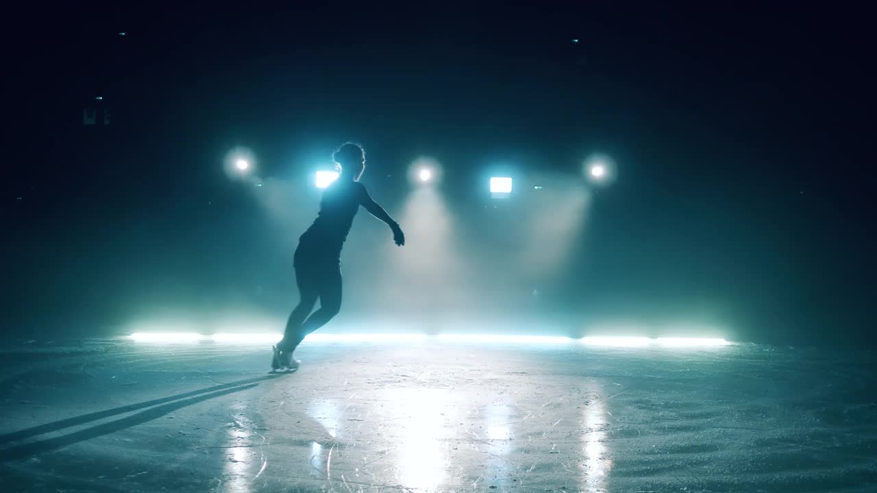 小女孩在溜冰场上滑冰，做旋转运动视频素材