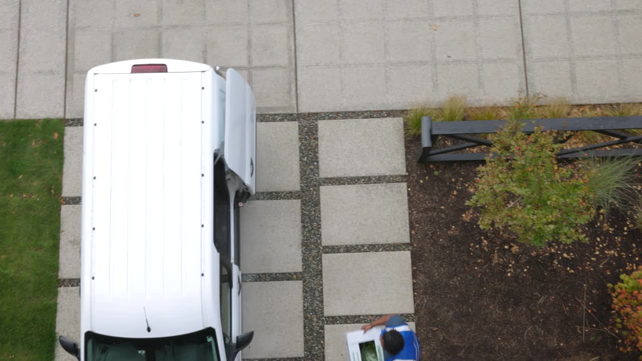 从头顶拍摄的男性送货司机正在家里把成箱的农产品装进货车视频素材