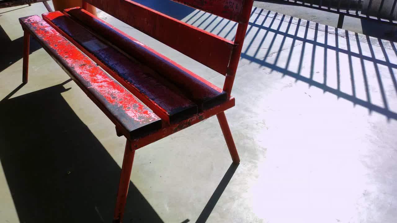 阳光下的老红色长凳慢动作视频素材
