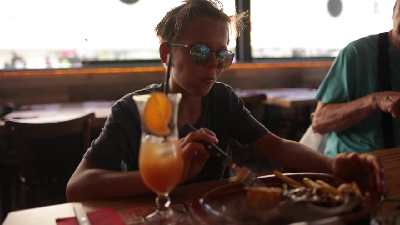 一个十几岁的男孩在餐厅吃午饭视频素材