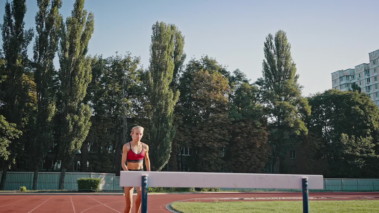 一个专业慢跑的金发女孩的特写阳光肖像。女人带着障碍跑一段距离，障碍赛跑的概念视频下载