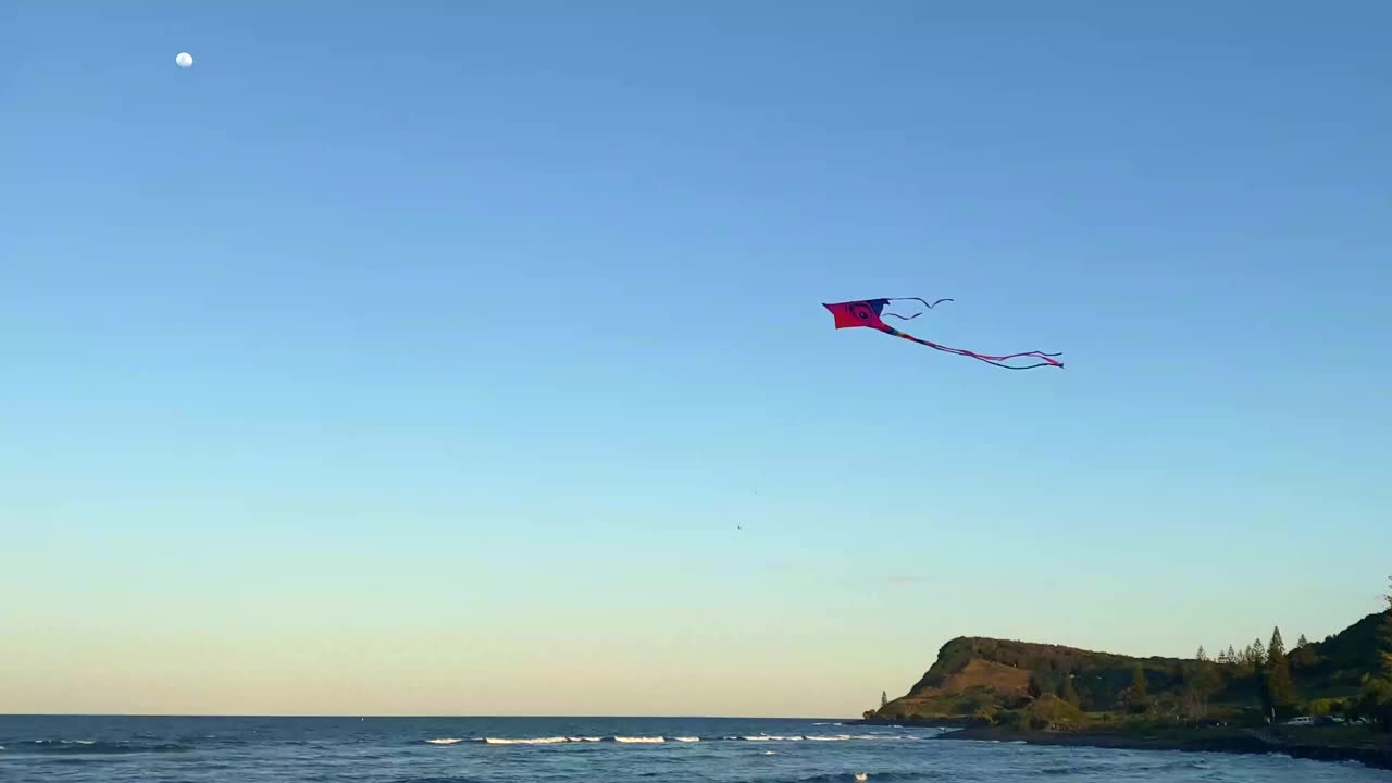 在日落月光下的海洋里放风筝视频下载