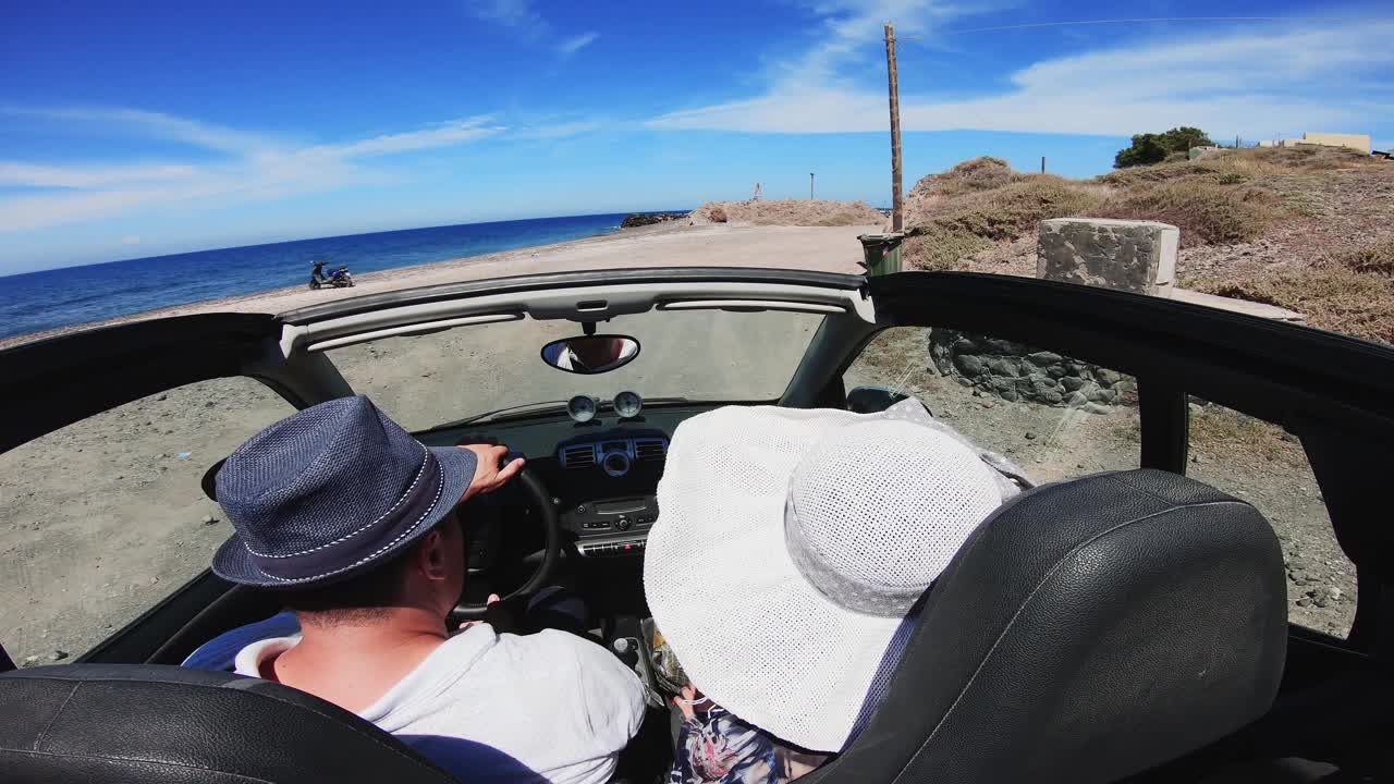 希腊圣托里尼岛，一对悠闲的情侣坐在敞篷车上视频素材