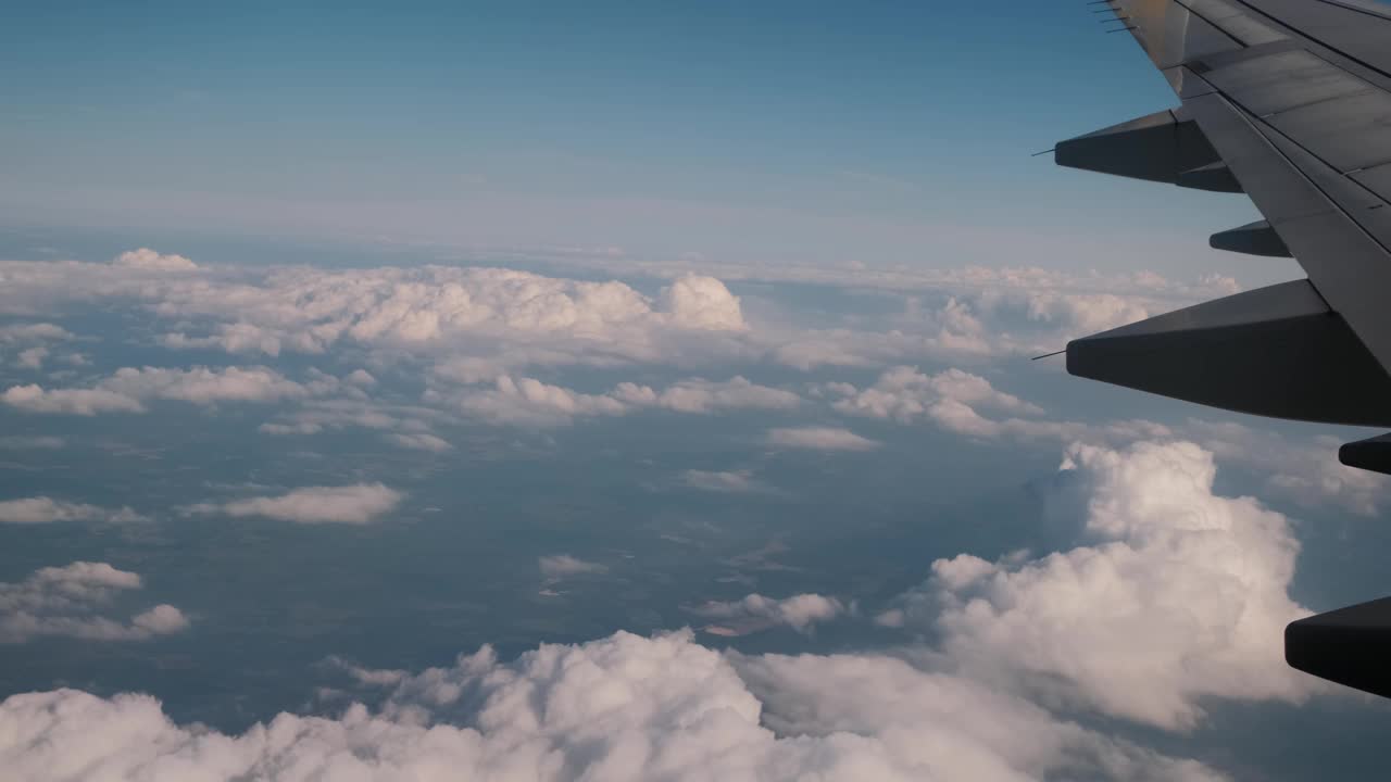 在云层上飞行的飞机的机翼。从飞机的窗户看。视频素材