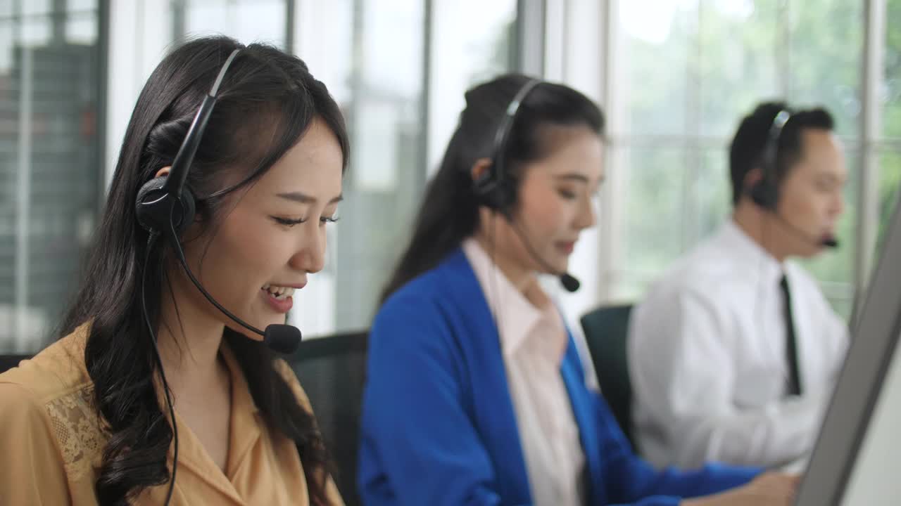 一组呼叫中心代理人员在客户的工作站与客户交谈视频素材