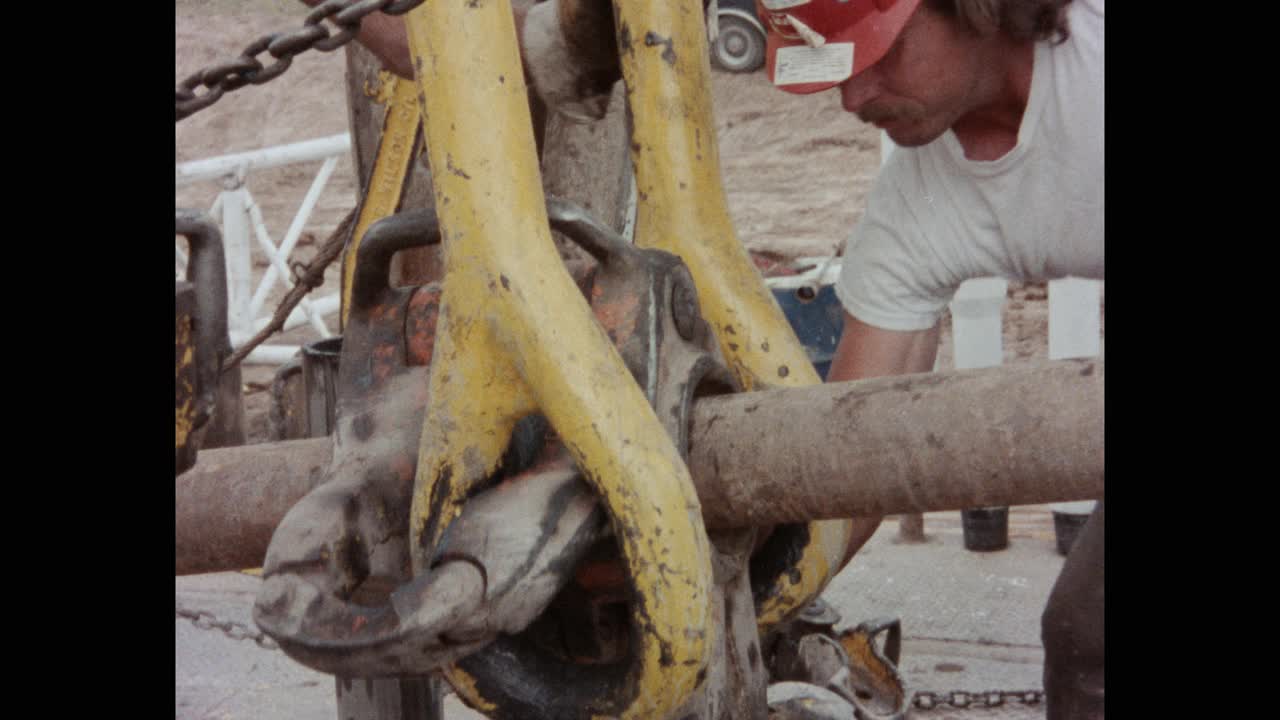 图为美国堪萨斯州油田的石油钻塔工人用起重机吊起重管视频下载
