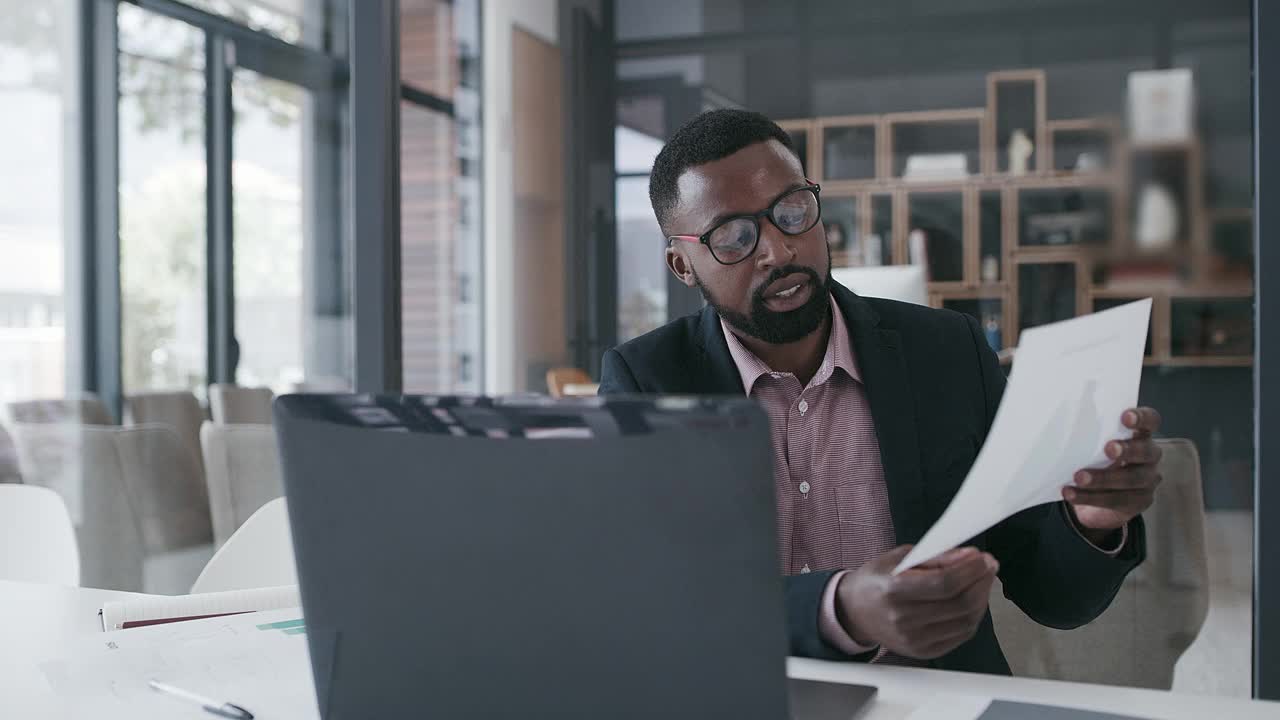 一个年轻的商人独自坐在办公室里用笔记本电脑开电话会议视频下载