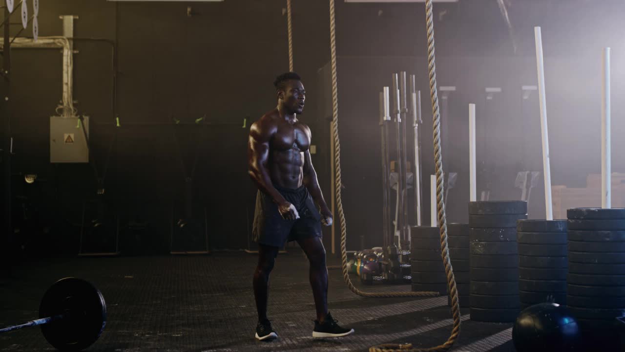 一个肌肉发达的男人在健身房爬绳子的4k视频片段视频素材