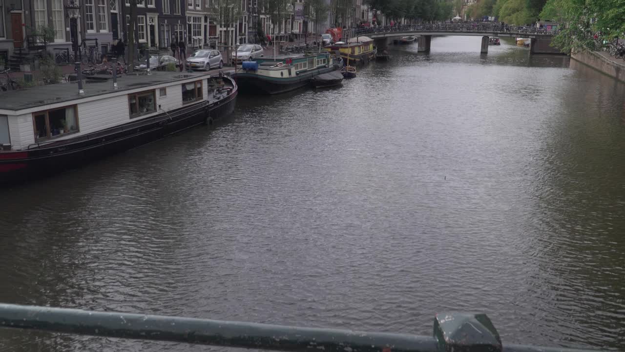 沿着阿姆斯特丹运河的步行街与一艘船在恶劣的天气，倾斜视图视频素材
