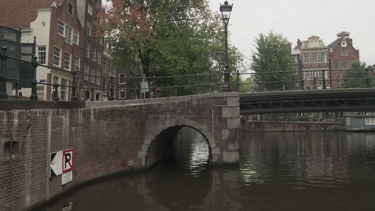 荷兰风格的房子在阿姆斯特丹沿运河的一排，在恶劣的天气，平移视图，低角度视图。视频素材