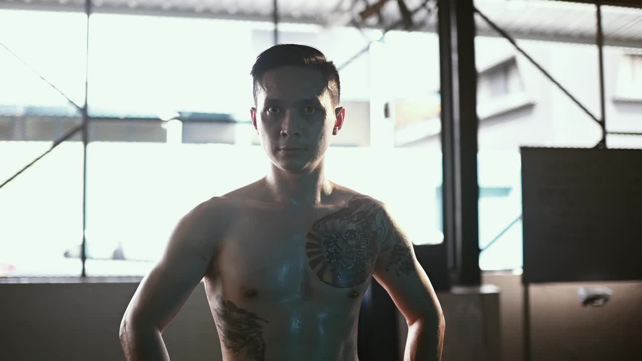 在健身俱乐部，亚洲华人男性健美教练赤裸上身的肖像照视频下载
