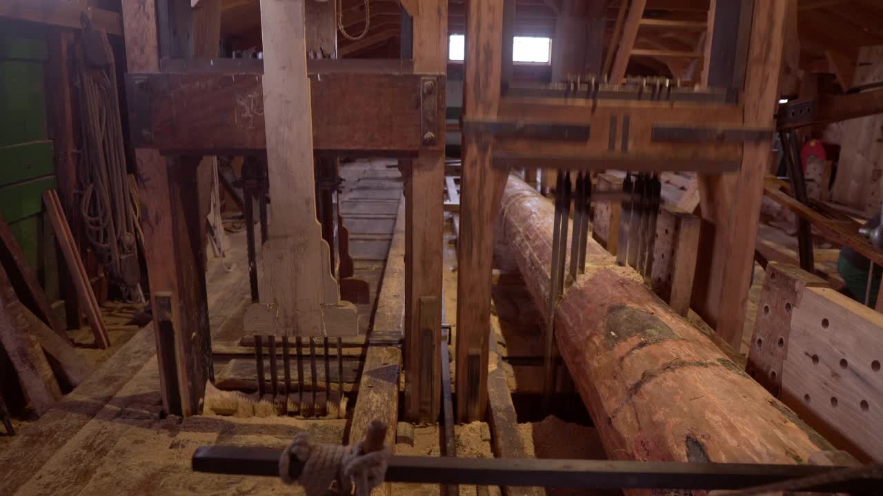 自制锯工作，通过使用来自风车的老式机制的力量来切割树干，木制结构与变速使其自动工作，连接到风车的齿轮在Zaanse Schans，荷兰，正面视图视频下载