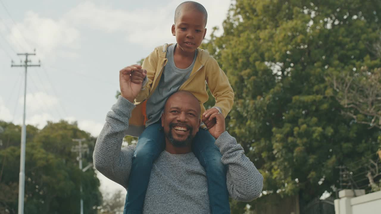 一个英俊成熟的男人扛着儿子在外面的4k视频视频素材