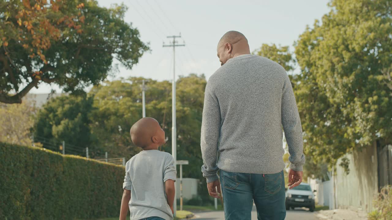 一段4k视频显示一名面目全非的男子和他儿子手拉手走在外面视频素材