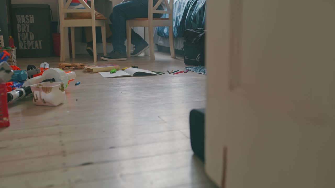 一个帅气成熟的男人在卧室帮儿子做作业的4k视频视频素材