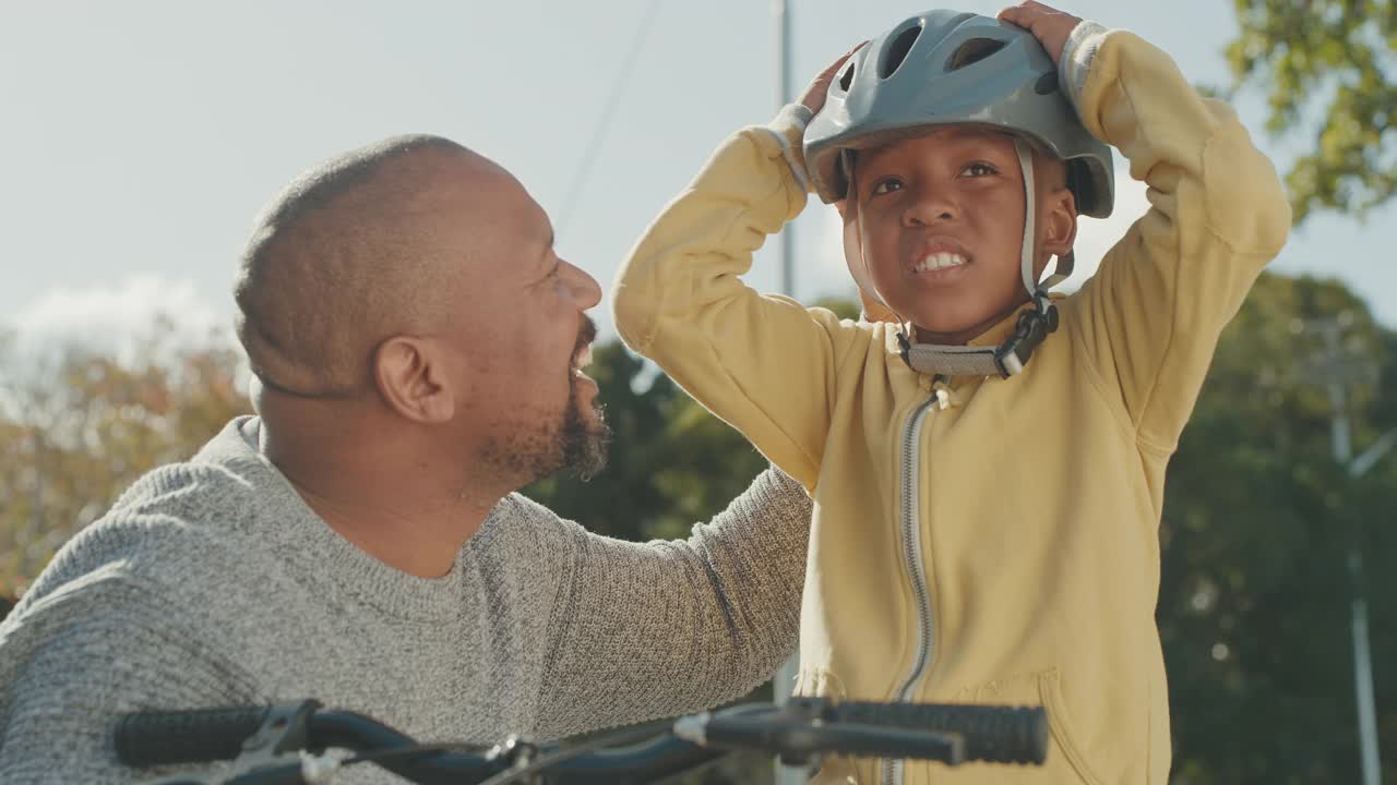 一个英俊成熟的男人教儿子在户外骑自行车的4k视频片段视频素材