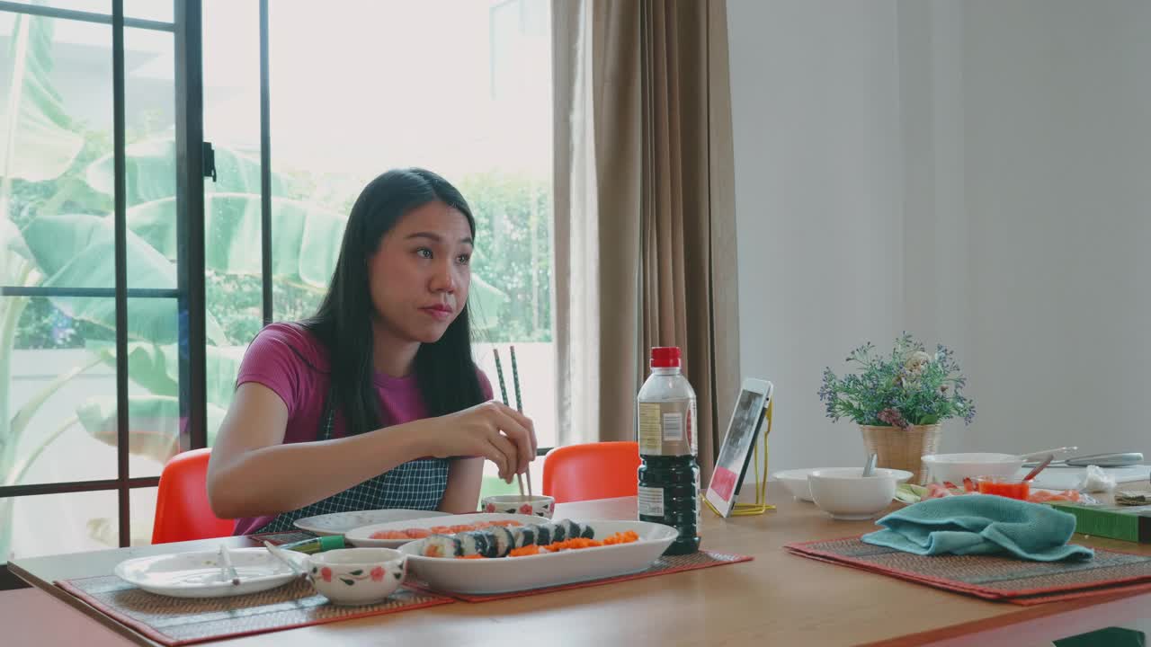 一个东南亚女人在家做寿司卷。视频下载