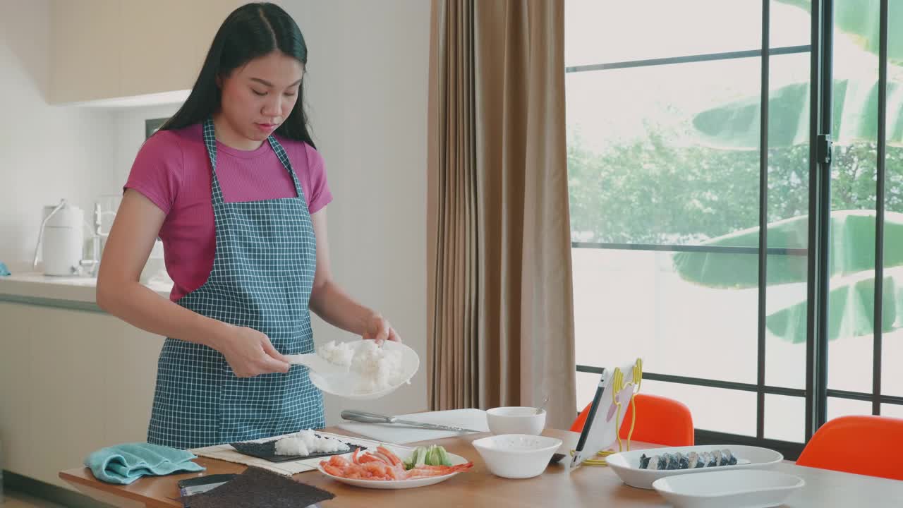 一个东南亚女人在家做寿司卷。视频下载