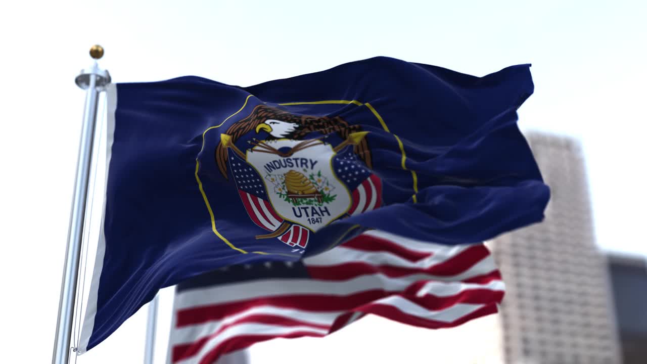美国犹他州的国旗迎风飘扬，背景是模糊的美国星条旗。视频下载