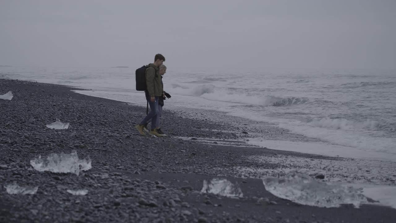 遥远的夫妇从黑色沙滩的海浪/冰岛视频下载
