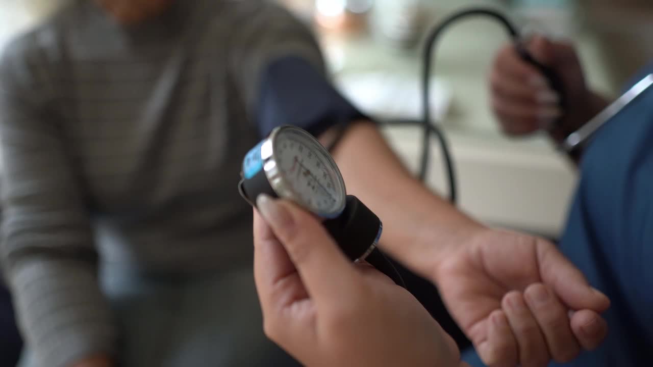 护士在家中给一位老年病人量血压视频下载