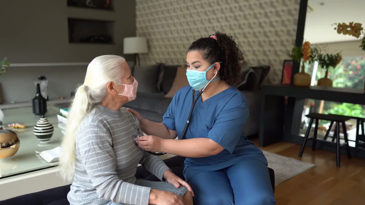 家访时，护士佩戴防护口罩，倾听老年患者的心跳视频下载