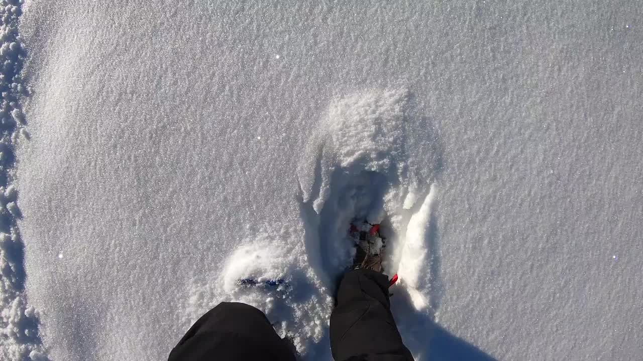 在刚下过雪的地方踩雪。山路。POV，徒步旅行者的观点。靠近雪鞋。踩在新雪上视频下载