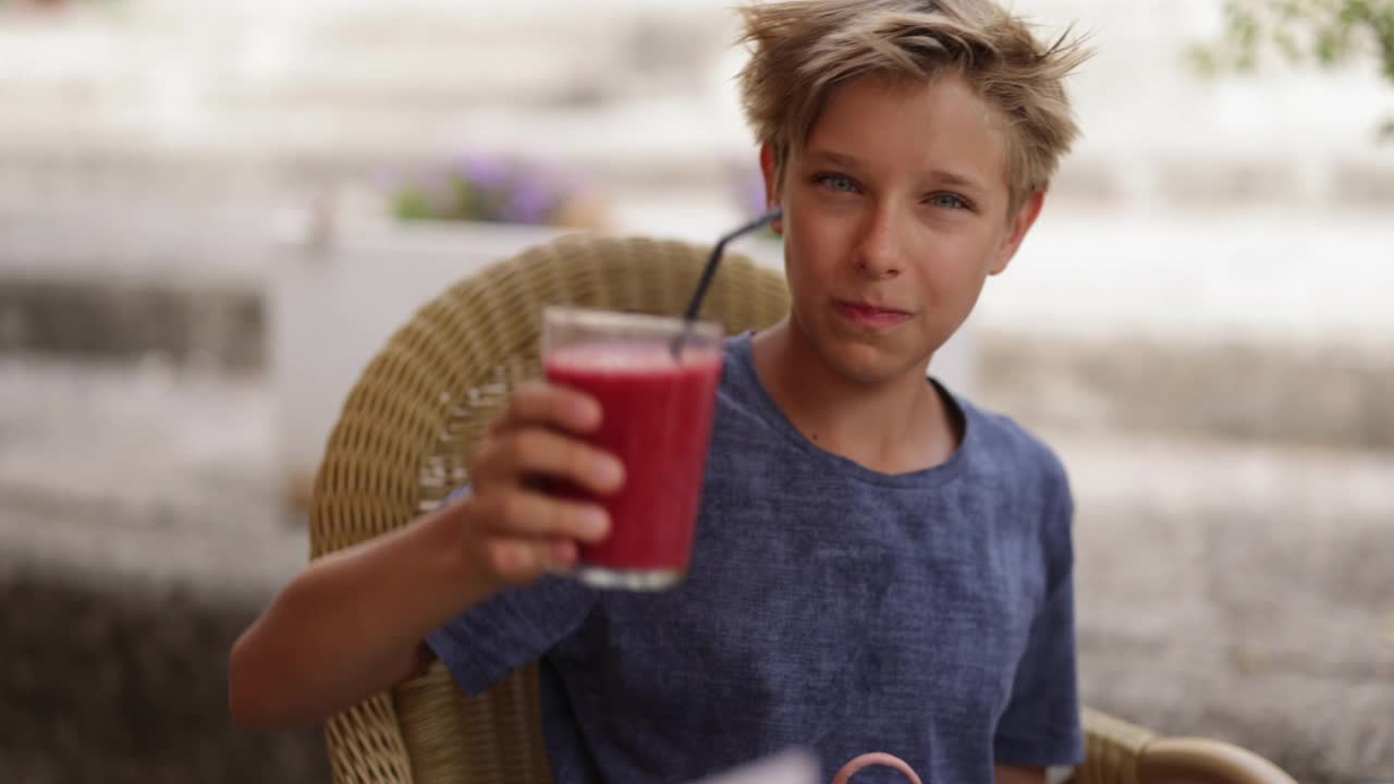 一个十几岁的男孩在餐厅喝着健康的冰沙视频素材