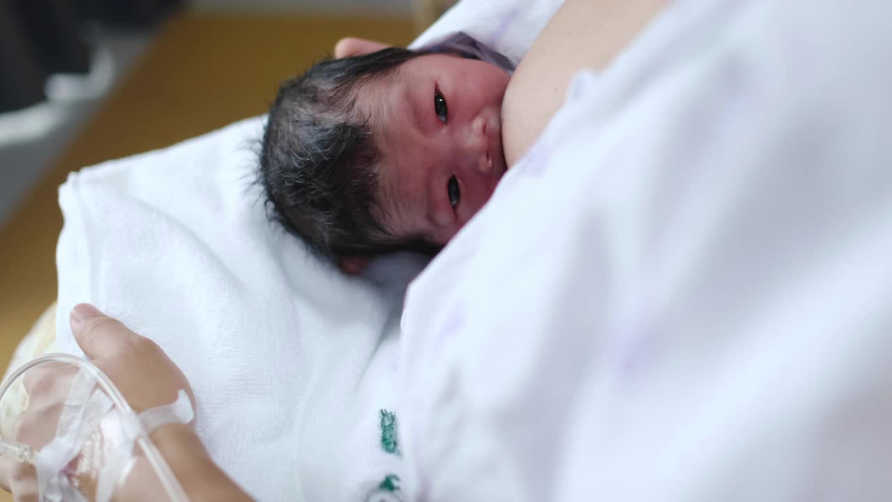年轻漂亮的母亲，在医院给她刚出生的男婴喂奶视频下载