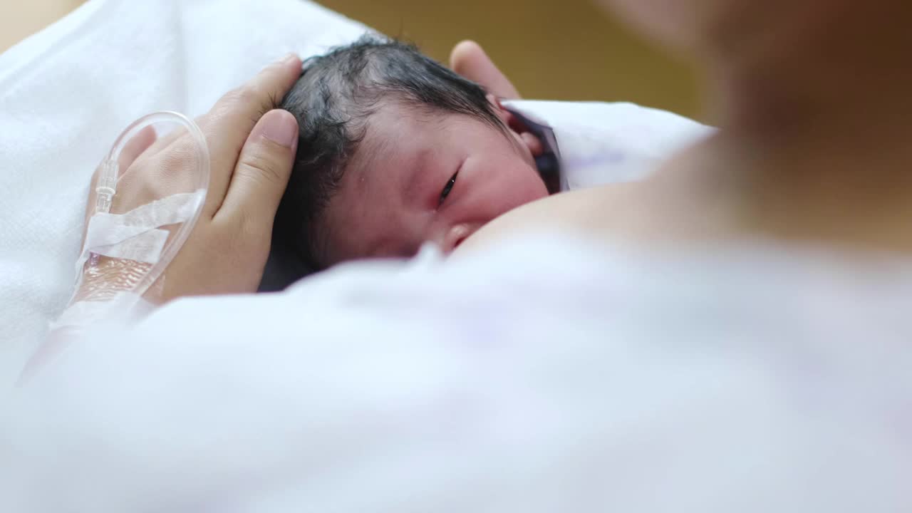 年轻漂亮的母亲，在医院给她刚出生的男婴喂奶视频下载