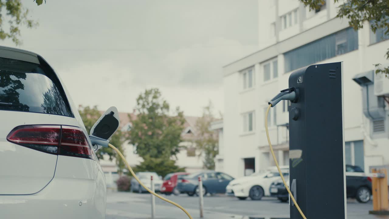 一名女子在为她的电动汽车充电时进行移动支付视频素材