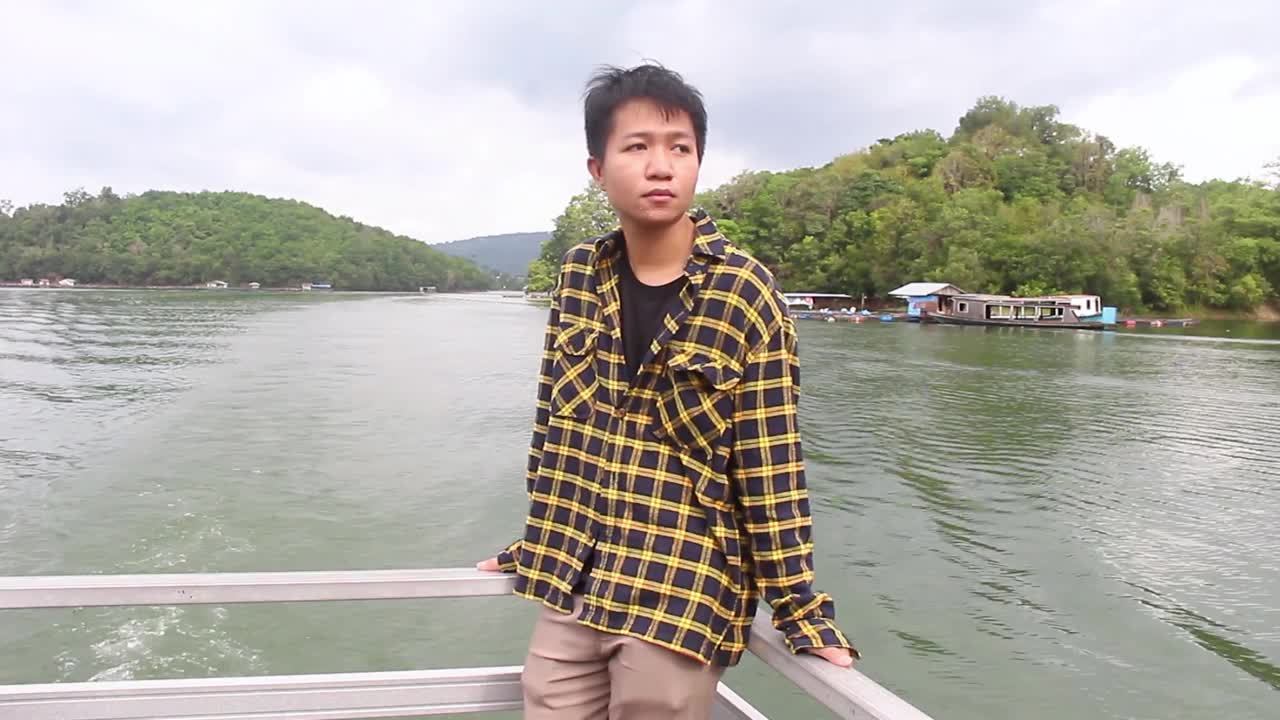 年轻男子在湖边划船放松视频下载
