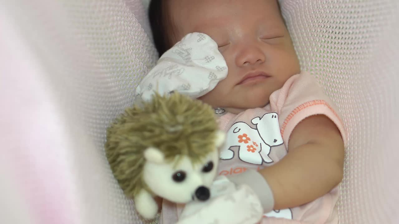 刚出生的宝宝和刺猬玩具一起睡觉视频素材