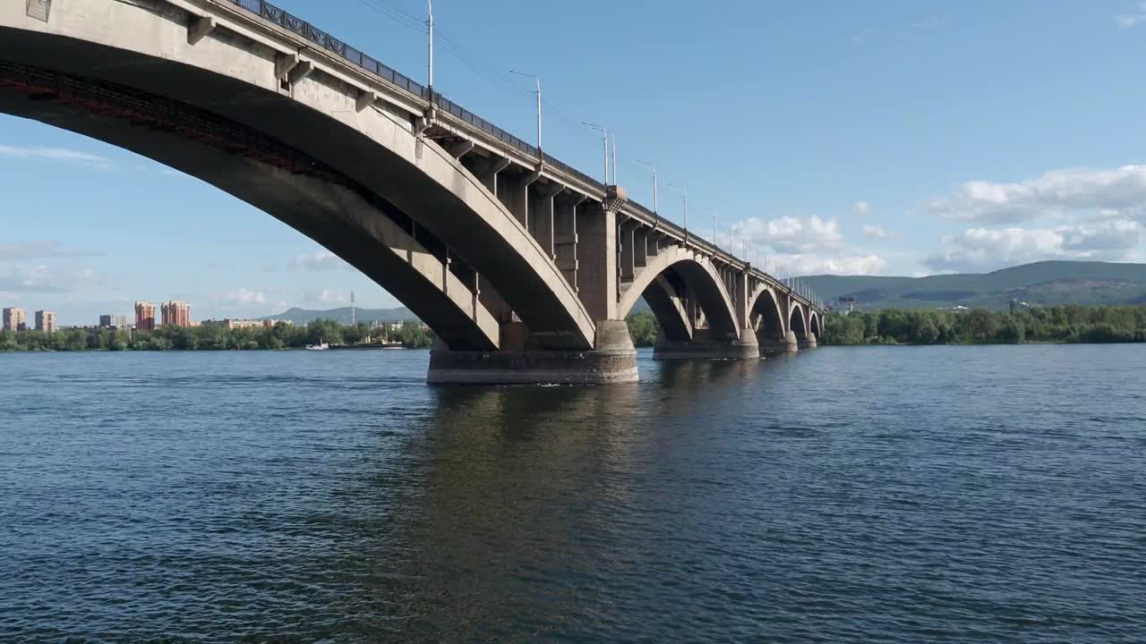 阳光明媚的夏日，克拉斯诺亚尔斯克的公共桥。叶尼塞河和公共桥。视频4 k的决议视频素材