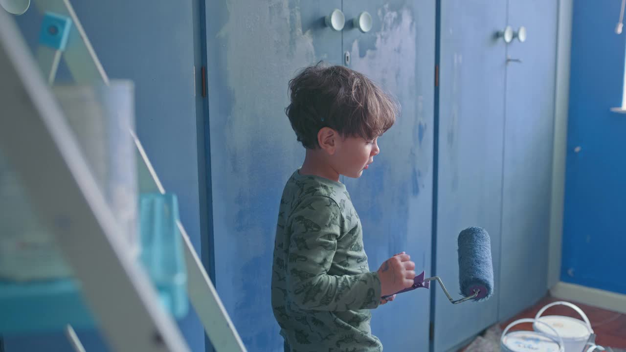 一个可爱的小男孩在家粉刷房间的4k视频片段视频下载