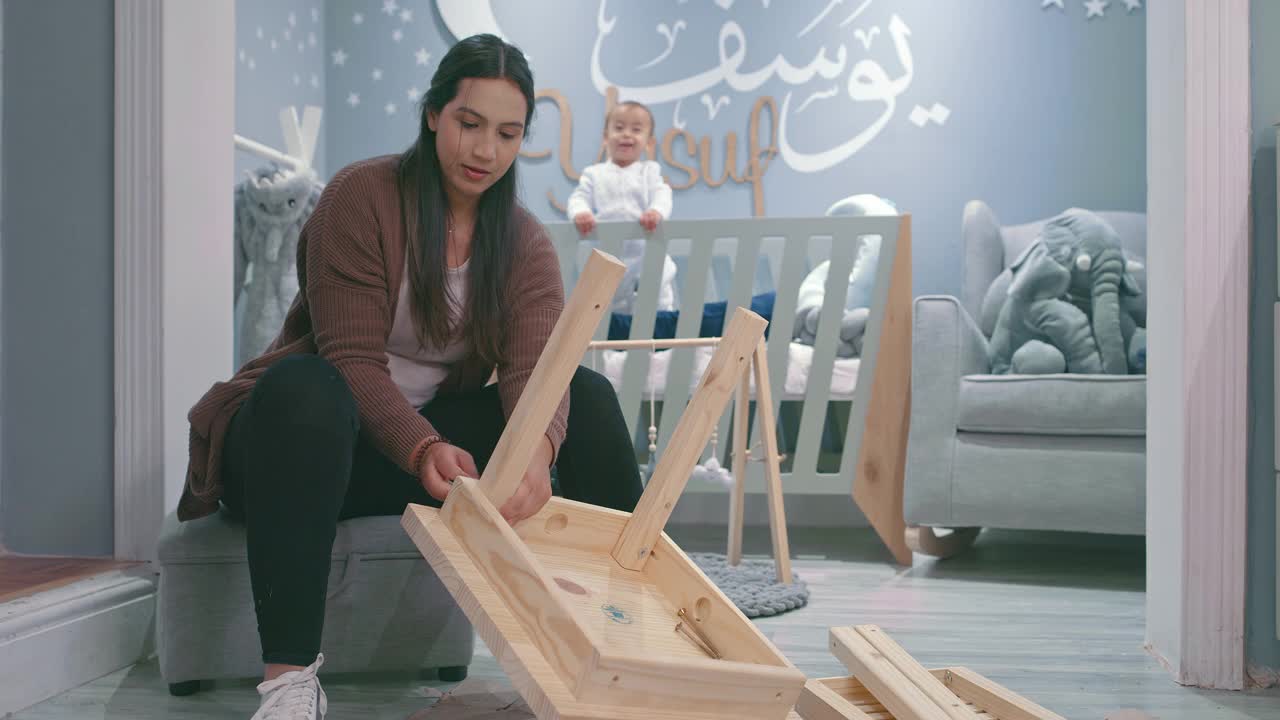 一段4k视频记录了一名年轻女子在家里的婴儿房做木制工程视频下载