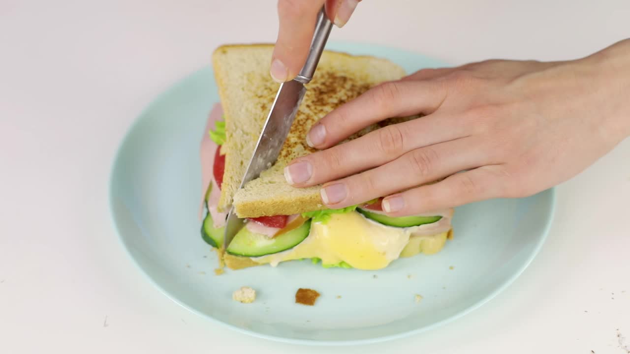 女性用刀切三明治的特写镜头视频下载