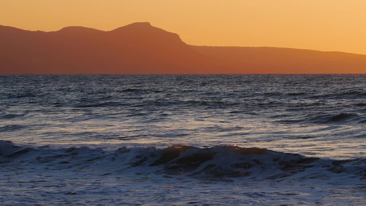 自然戏剧性的海景，日出与山脉，夕阳照耀着金色的波浪，海洋和海洋慢动作4k视频素材