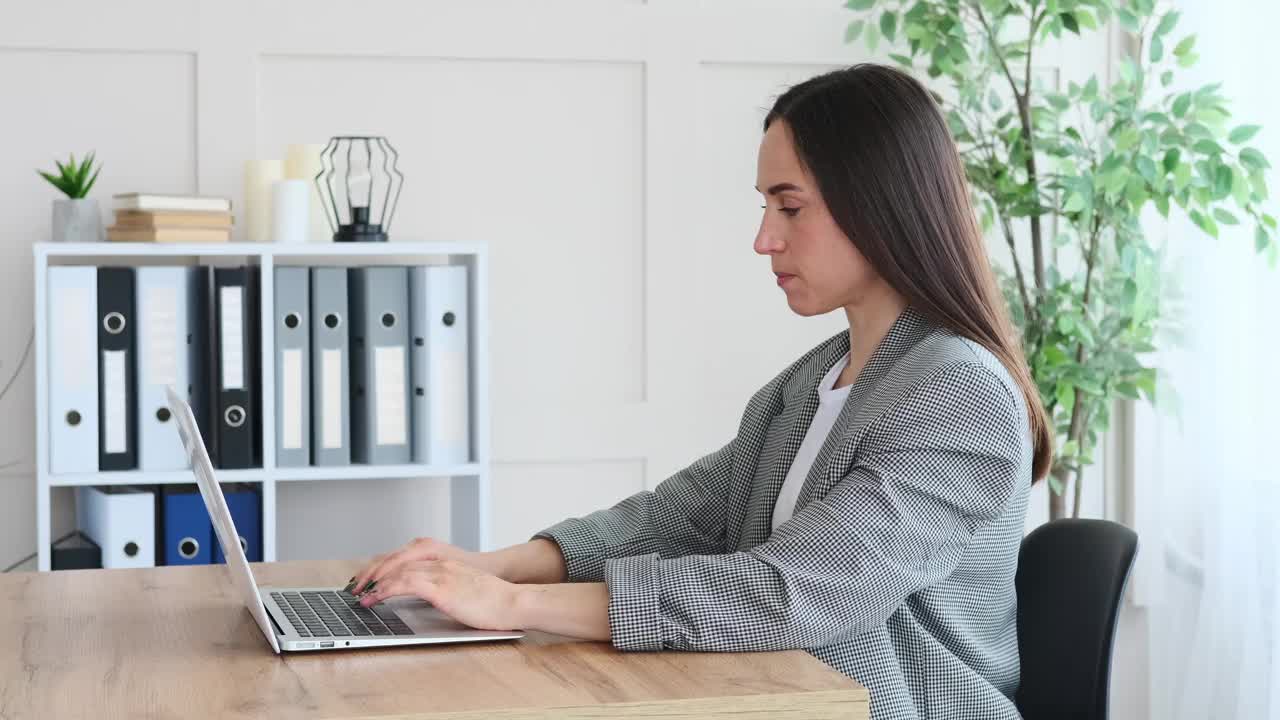 女商人在办公室用笔记本电脑庆祝网上成功视频素材