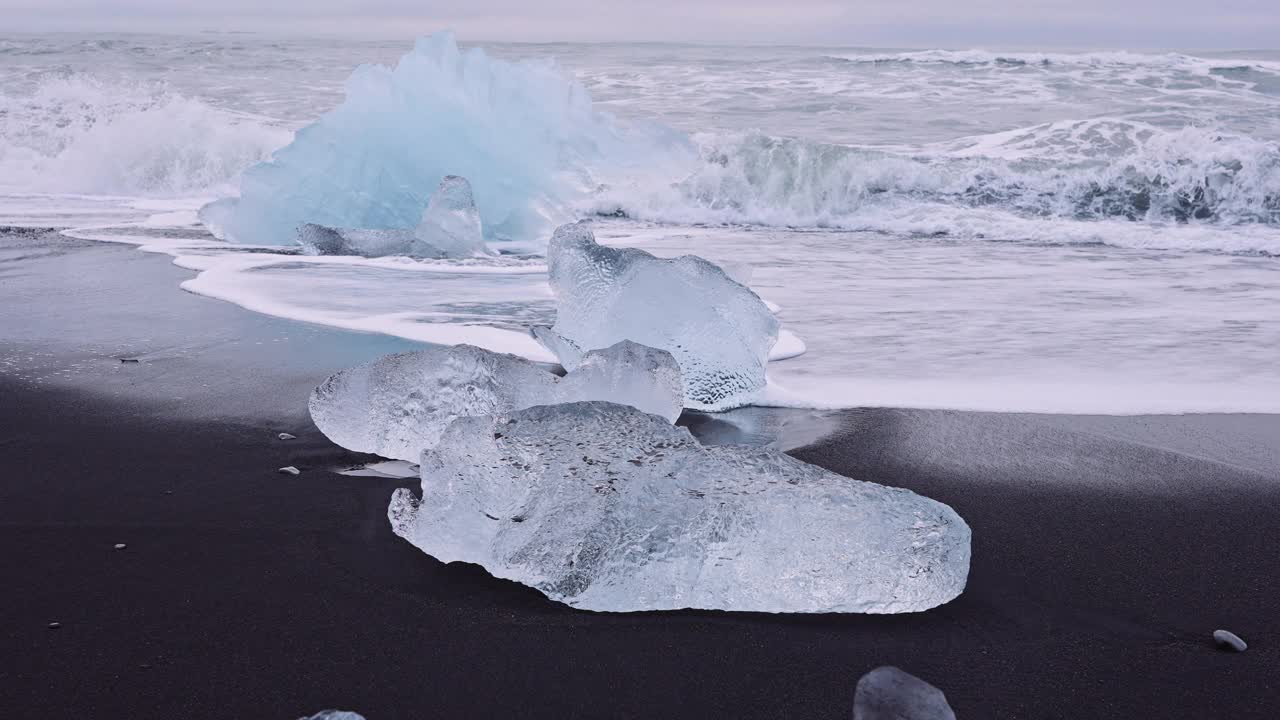 冰岛冰川泻湖附近钻石海滩上的冰上的波浪视频下载