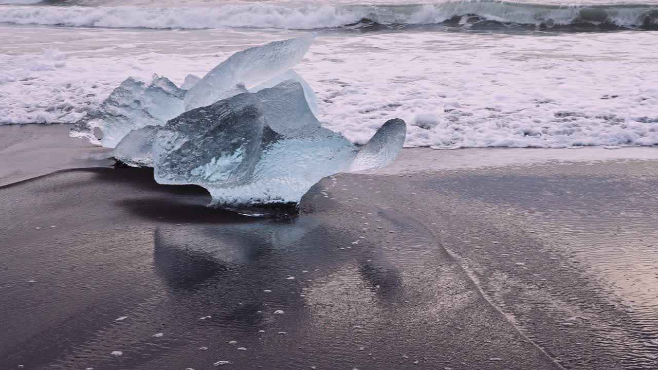 在冰岛冰川泻湖附近的钻石海滩的冰面上冲浪视频下载