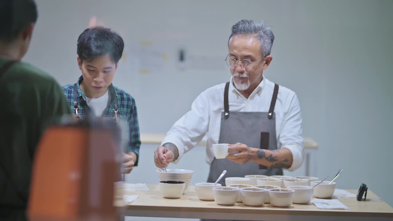 亚洲华人资深男咖啡师在工作室工作地点拔火罐品尝咖啡样品视频素材