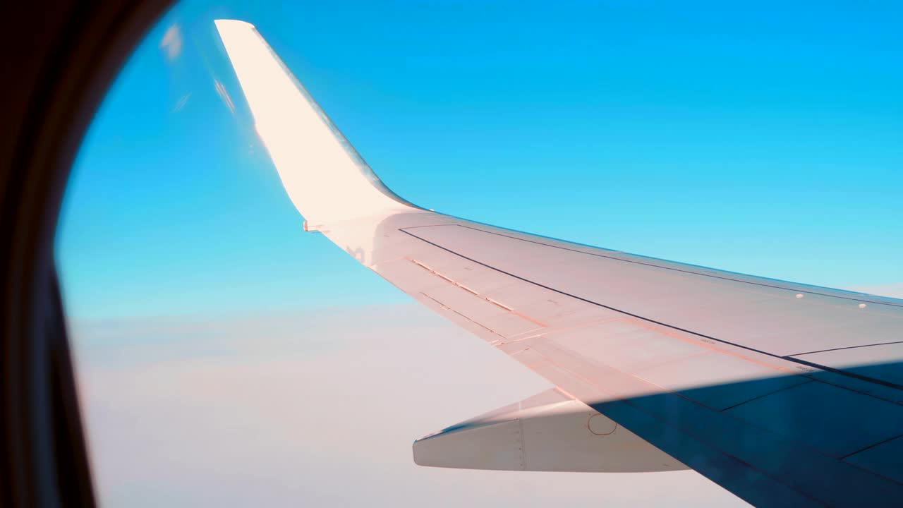 当在飞机上飞行时，看着窗外的飞机机翼视频素材