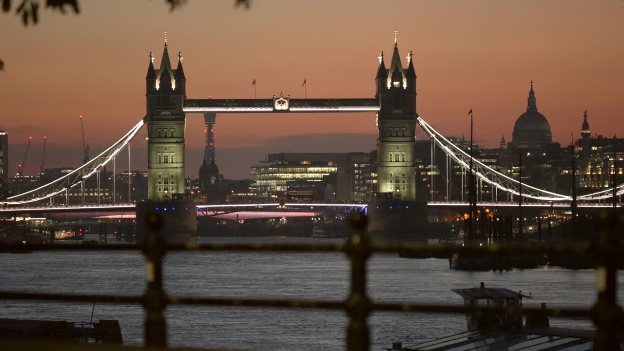 伦敦塔桥和圣保罗大教堂的圆顶在晚上从泰晤士河的河岸视频下载